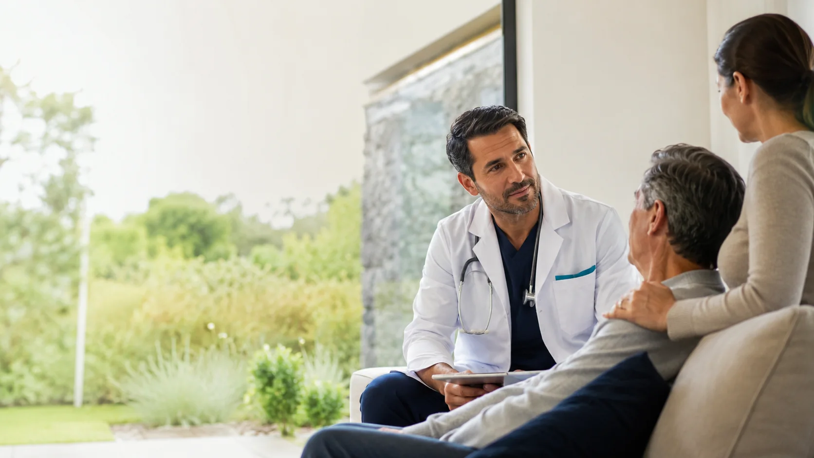 Médico a domicilio conversando con paciente y familia en casa